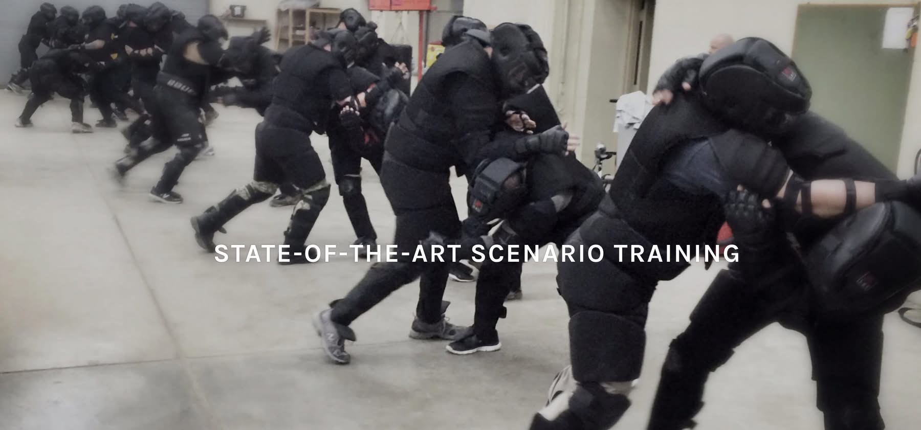 Large group in High Gear running full-contact scenario drills in a warehouse